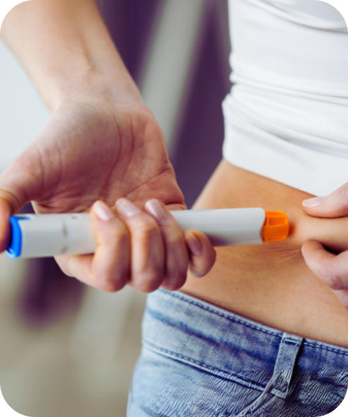 Frau führt am Bauch eine Abnehmspritze ein