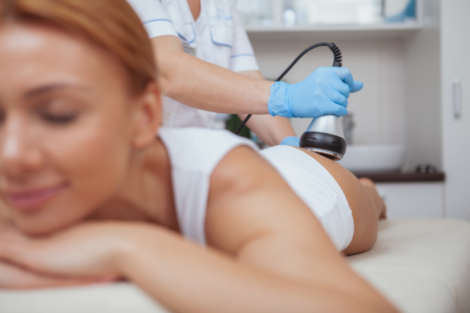 Beautiful woman getting ultrasound cavitation body treatment